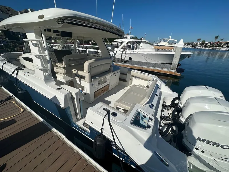 Slide: The Image of 2019 Boston Whaler 350 Realm docked, showcasing spacious seating and powerful engines. - 4
