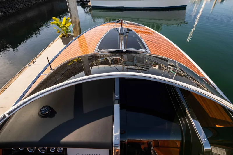 Slide: The Image of 2024 Riva 38 Rivamare luxury yacht with sleek wooden deck, docked in marina. - 11