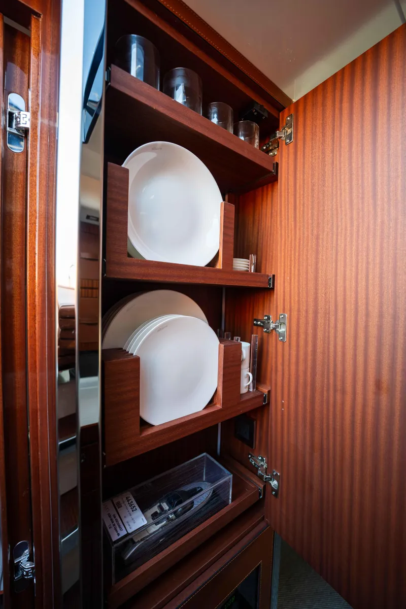 Slide: The Image of Wooden cabinet with neatly arranged dishes and glasses on a 2024 Riva 38 Rivamare yacht. - 15