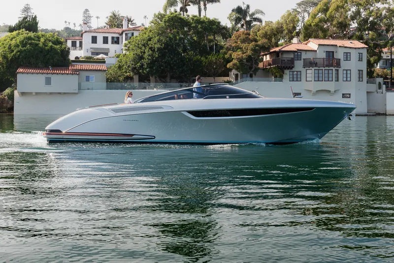 Slide: The Image of 2024 Riva 38 Rivamare luxury yacht cruising on calm waters near elegant waterfront homes. - 4