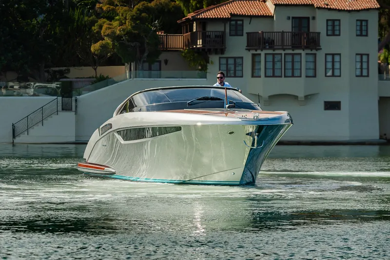 Slide: The Image of 2024 Riva 38 Rivamare yacht cruising near elegant waterfront property. - 5