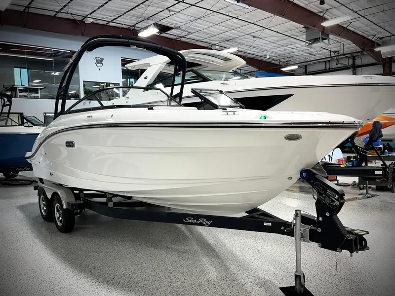 Slide: The Image of 2025 Sea Ray SPX 210 boat on trailer in showroom. - 1