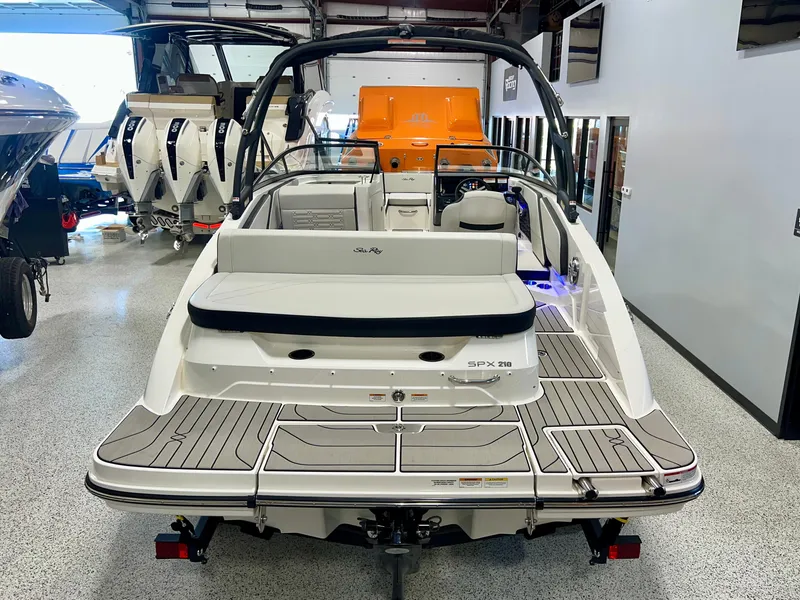 Slide: The Image of 2025 Sea Ray SPX 210 boat in showroom, rear view, sleek design, modern features. - 12