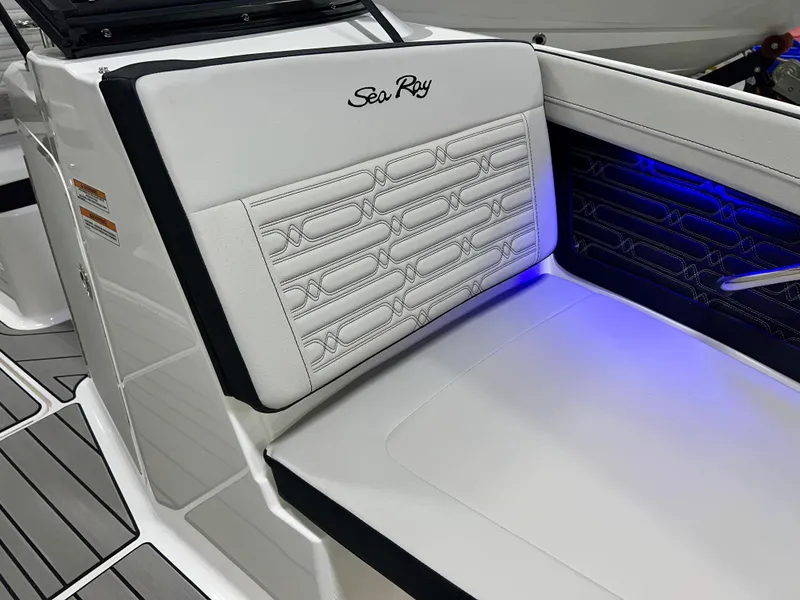 Slide: The Image of 2025 Sea Ray SPX 210 boat interior with white seating and blue LED lighting. - 34