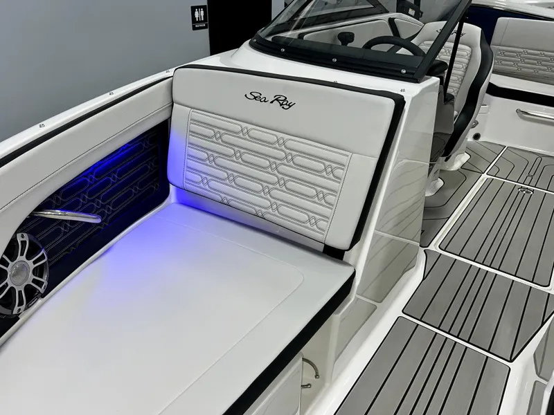 Slide: The Image of 2025 Sea Ray SPX 210 boat interior with white seating and blue LED lighting. - 35