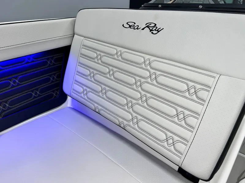 Slide: The Image of 2025 Sea Ray SPX 210 boat interior with elegant white upholstery and blue ambient lighting. - 36