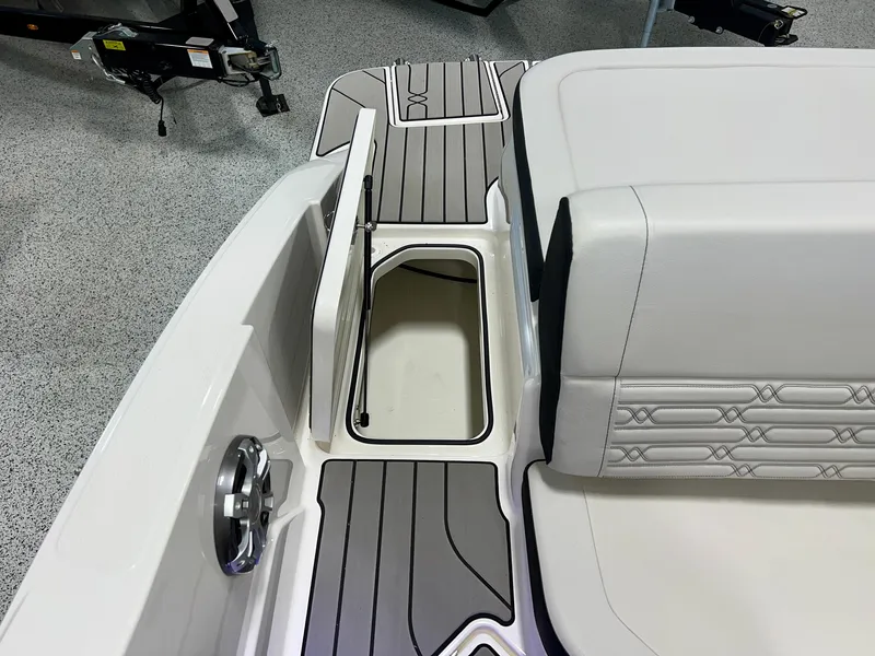 Slide: The Image of 2025 Sea Ray SPX 210 boat interior with storage compartment and cushioned seating. - 48