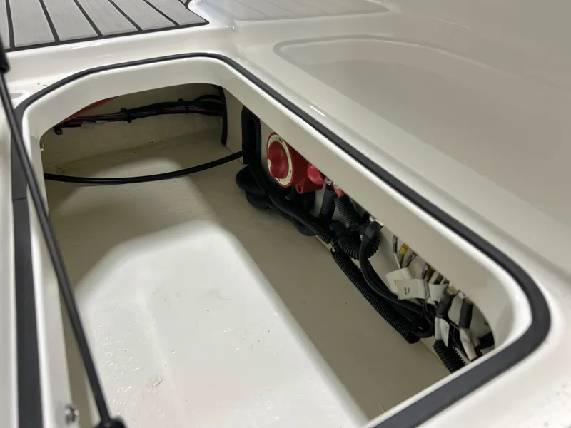 Slide: The Image of 2025 Sea Ray SPX 210 storage compartment with visible wiring and clean interior design. - 49