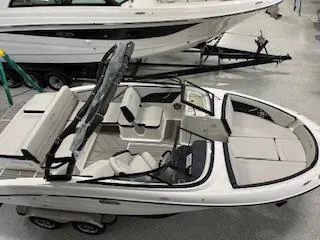 Slide: The Image of 2025 Sea Ray SPX 210 boat in showroom, top view, sleek design, white interior. - 54