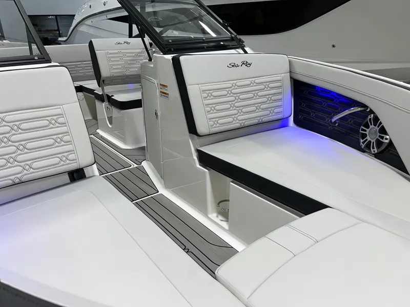 Slide: The Image of 2025 Sea Ray SPX 210 boat interior with white seating and blue accent lighting. - 6