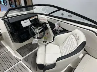 Slide: The Image of 2025 Sea Ray SPX 210 boat interior with steering wheel and white seating. - 64
