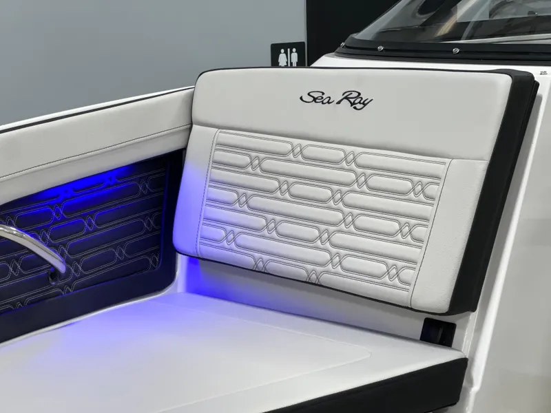 Slide: The Image of 2025 Sea Ray SPX 210 boat interior with elegant white seating and blue LED lighting. - 7