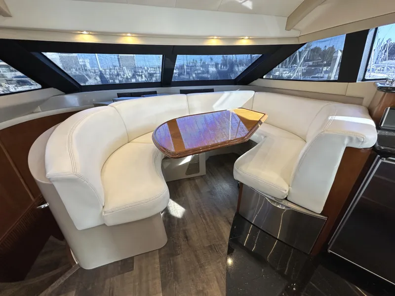 Slide: The Image of Luxurious 2004 Marquis 59 yacht interior with curved white seating and wooden table. - 10