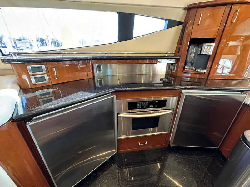 Slide: The Image of Luxurious 2004 Marquis 59 yacht kitchen with sleek wood cabinetry and stainless steel appliances. - 13