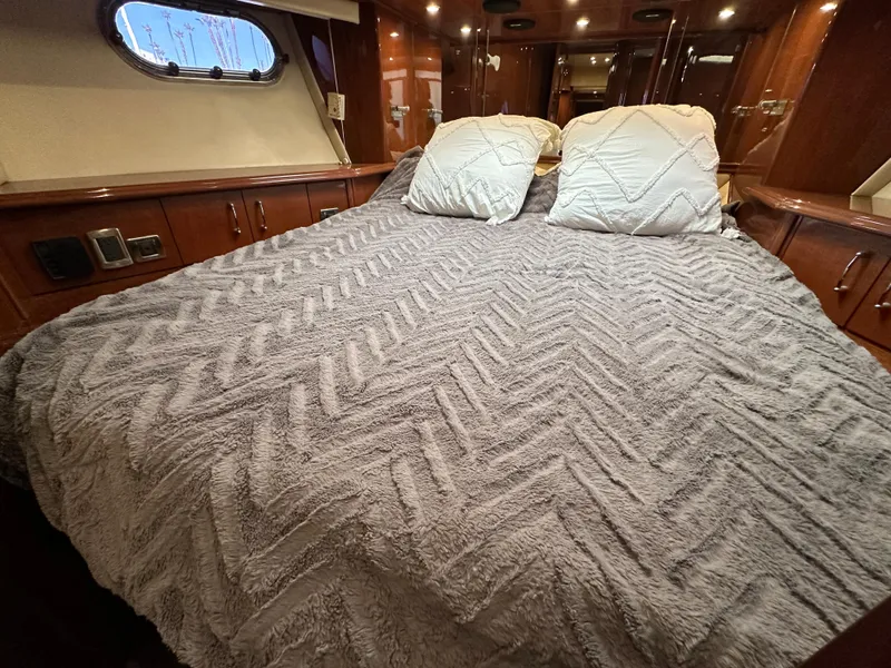 Slide: The Image of Luxurious bedroom interior of 2004 Marquis 59 yacht with plush bedding and wood accents. - 34