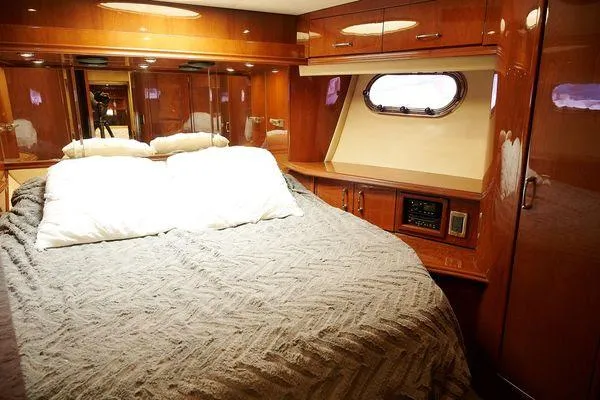 Slide: The Image of Luxurious 2004 Marquis 59 yacht bedroom with wood paneling and cozy bedding. - 35