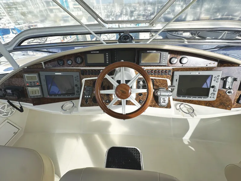 Slide: The Image of 2004 Marquis 59 yacht helm with wooden steering wheel and advanced navigation systems. - 44