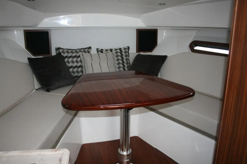 Slide: The Image of 2021 Pursuit OS 325 Offshore cabin with elegant seating and wooden table. - 10
