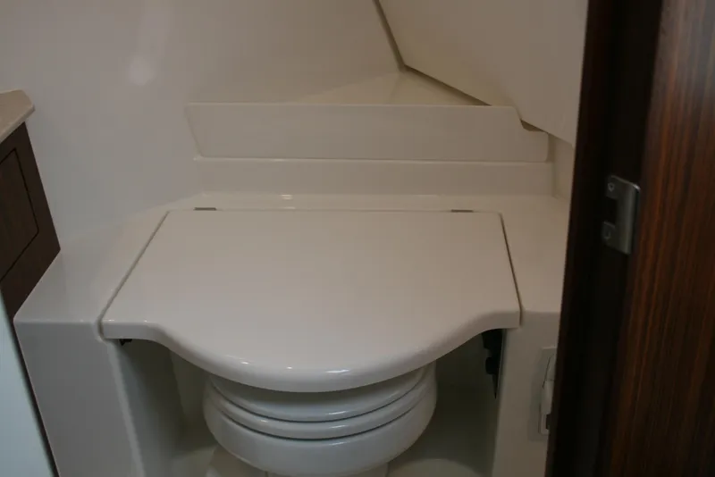Slide: The Image of 2021 Pursuit OS 325 Offshore boat bathroom with closed toilet lid. - 20