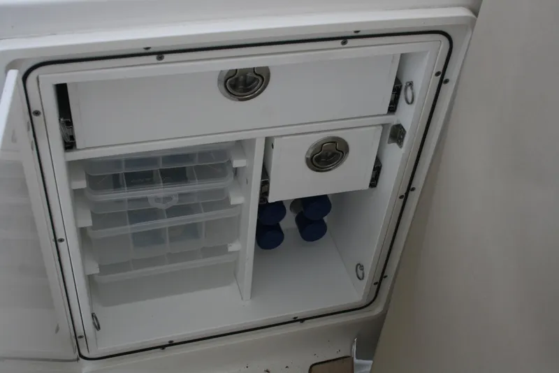Slide: The Image of 2021 Pursuit OS 325 Offshore storage compartment with organized drawers and shelves. - 22