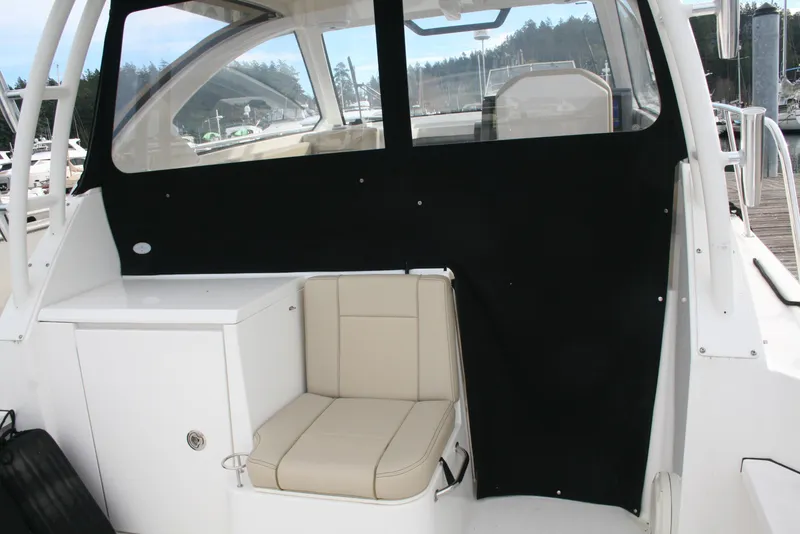 Slide: The Image of 2021 Pursuit OS 325 Offshore boat interior with beige seating and black panel. - 24