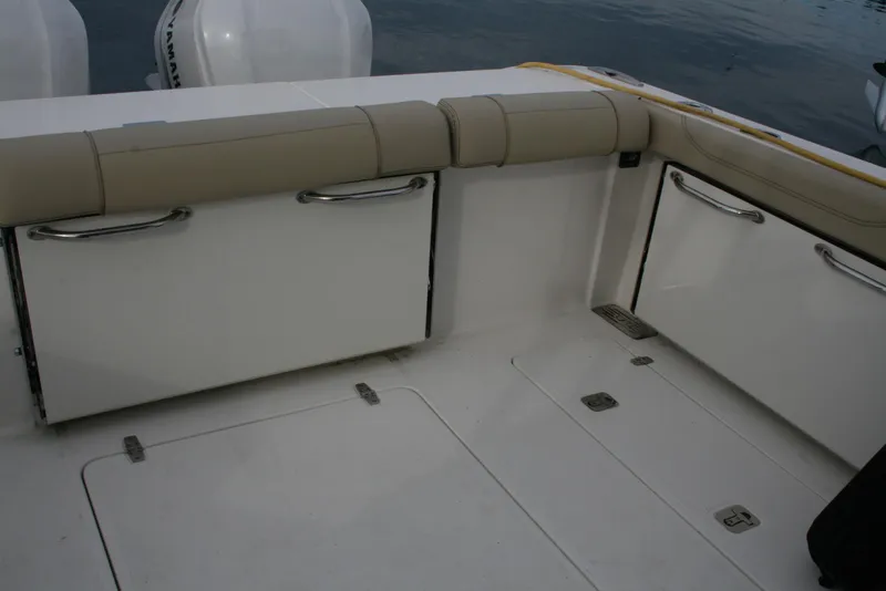 Slide: The Image of 2021 Pursuit OS 325 Offshore boat interior with storage compartments and cushioned seating. - 28