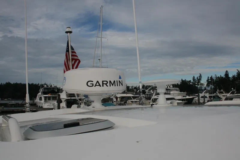 Slide: The Image of 2021 Pursuit OS 325 Offshore boat with Garmin radar and American flag in marina. - 30