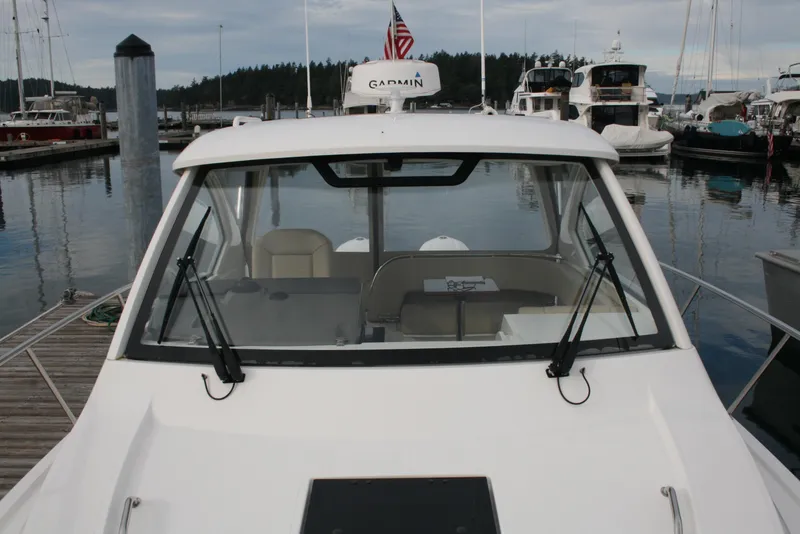 Slide: The Image of 2021 Pursuit OS 325 Offshore boat docked at marina with Garmin equipment. - 31