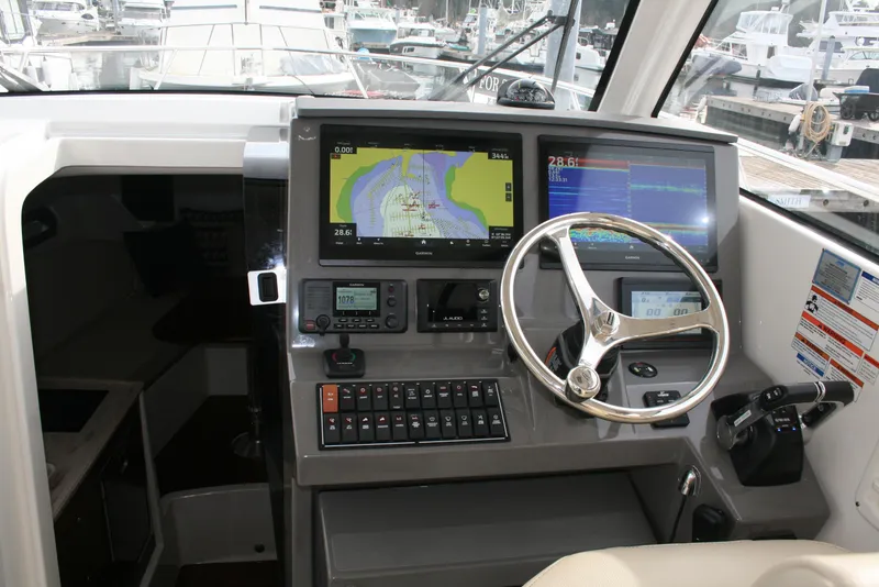 Slide: The Image of 2021 Pursuit OS 325 Offshore boat cockpit with navigation system and steering wheel. - 4