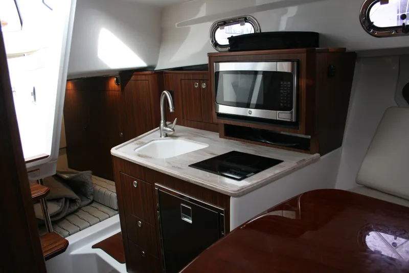 Slide: The Image of 2021 Pursuit OS 325 Offshore yacht interior with kitchenette, microwave, and sink. - 8