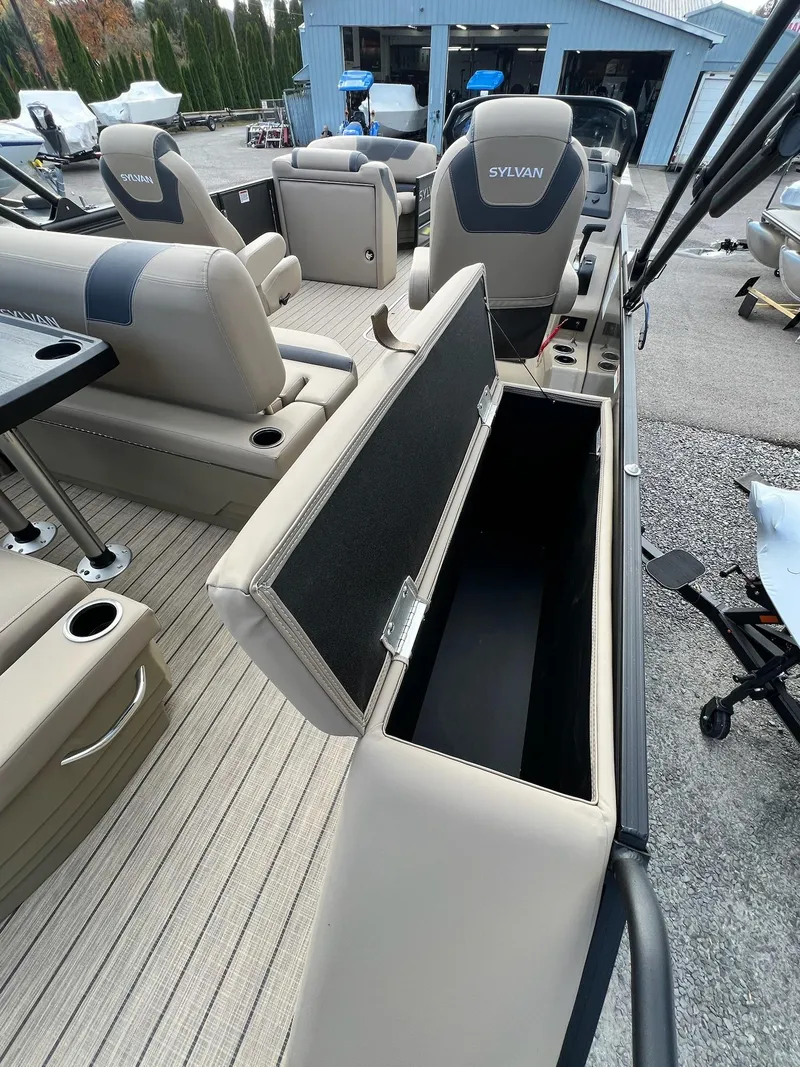 Slide: The Image of 2025 Sylvan L3 DLZ Tritoon interior with open storage compartment and seating. - 12