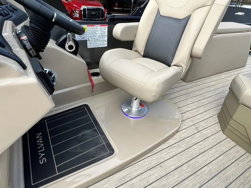 Slide: The Image of 2025 Sylvan L3 DLZ Tritoon helm with beige captain's chair and steering wheel. - 13