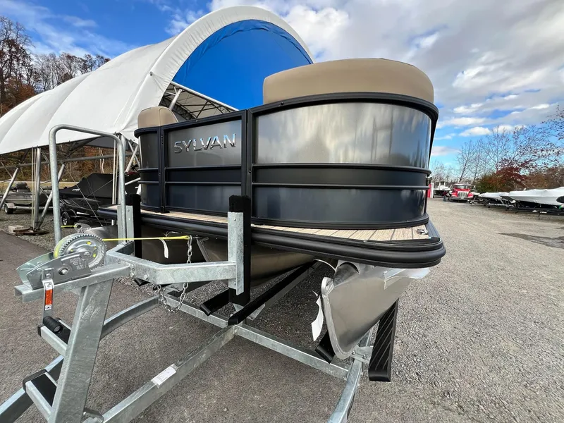 Slide: The Image of 2025 Sylvan L3 DLZ Tritoon boat on trailer, outdoor storage area. - 15