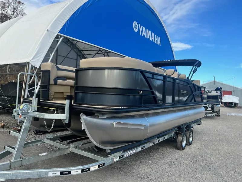 Slide: The Image of 2025 Sylvan L3 DLZ Tritoon boat on trailer near Yamaha tent. - 18