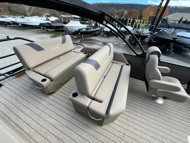 Slide: The Image of 2025 Sylvan L3 DLZ Tritoon boat interior with beige seating and cup holders. - 25