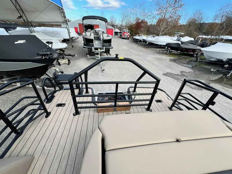 Slide: The Image of 2025 Sylvan L3 DLZ Tritoon boat on display in a marina lot. - 4