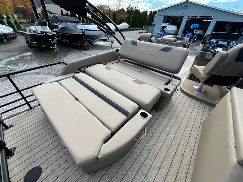 Slide: The Image of 2025 Sylvan L3 DLZ Tritoon with luxurious seating and modern design in a boatyard. - 43
