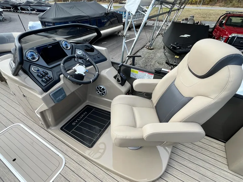 Slide: The Image of 2025 Sylvan L3 DLZ Tritoon helm with luxurious captain's chair and modern dashboard controls. - 47