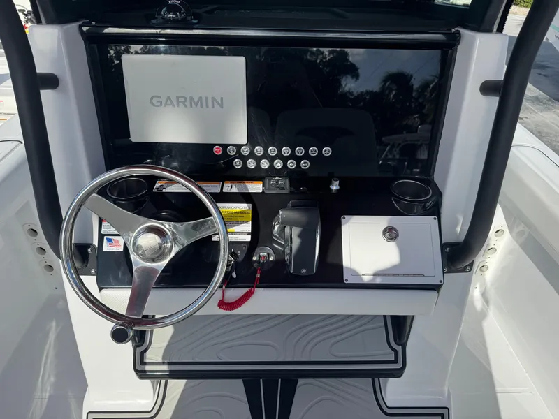 Slide: The Image of 2025 Wellcraft 243 Fisherman dashboard with Garmin navigation system and steering wheel. - 11
