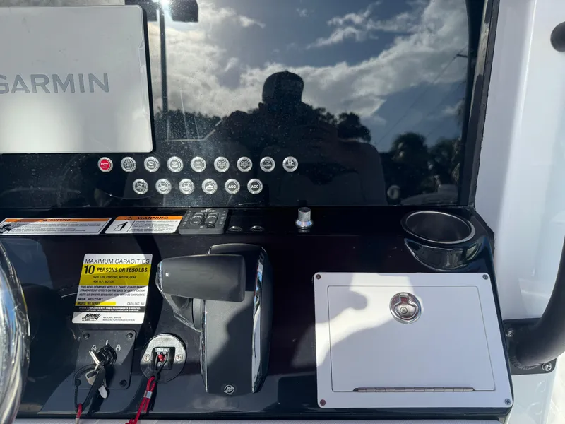 Slide: The Image of 2025 Wellcraft 243 Fisherman dashboard with Garmin navigation system and control panel. - 12