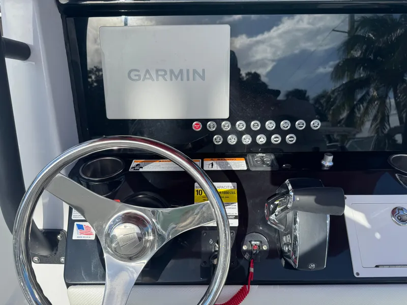 Slide: The Image of 2025 Wellcraft 243 Fisherman dashboard with Garmin navigation system and steering wheel. - 13