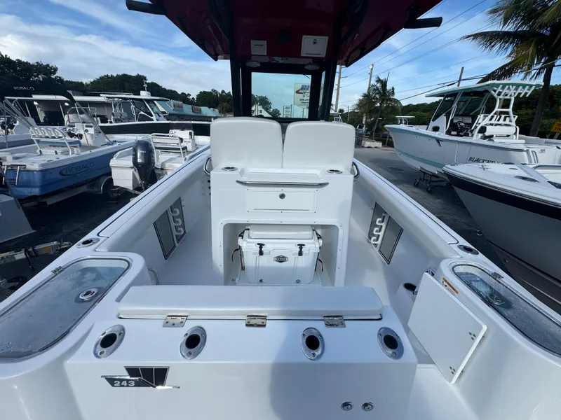 Slide: The Image of 2025 Wellcraft 243 Fisherman boat interior with seating and storage, docked among other boats. - 5