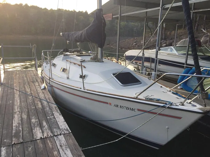 The Image of Pearson 27 sailboat docked, 1990 model, with covered sails and serene water backdrop. - 1