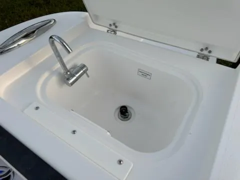 Slide: The Image of 2024 Crevalle 33 CSF boat sink with faucet and open lid. - 33