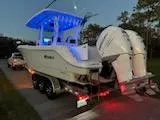 Slide: The Image of 2024 Crevalle 33 CSF boat on trailer with illuminated blue canopy at dusk. - 39