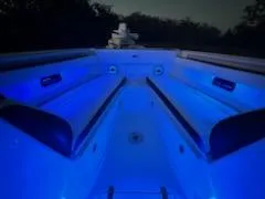 Slide: The Image of 2024 Crevalle 33 CSF boat interior with blue LED lighting at night. - 45