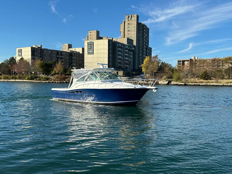 Slide: The Image of 2011 Rampage 34 IPS boat cruising on a sunny day near urban buildings. - 11