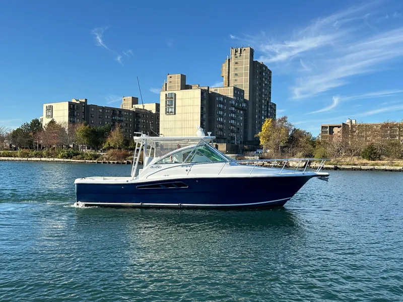 Slide: The Image of 2011 Rampage 34 IPS boat cruising on a river with cityscape background. - 12