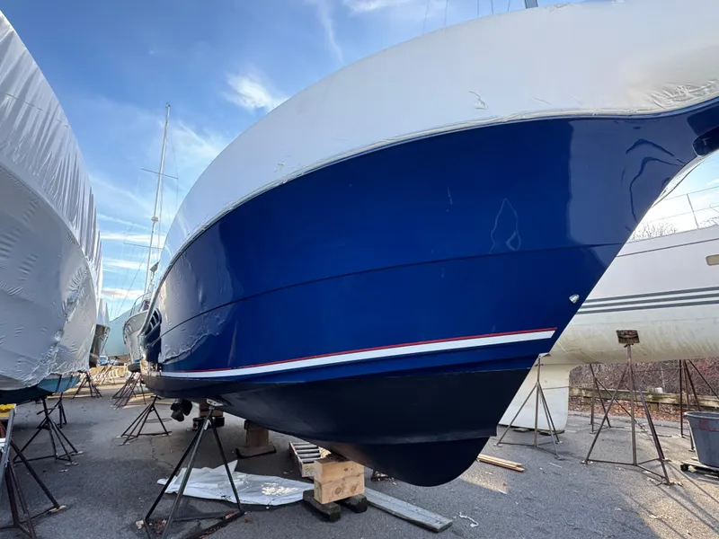 Slide: The Image of 2011 Rampage 34 IPS boat in dry dock, blue hull, clear sky background. - 13