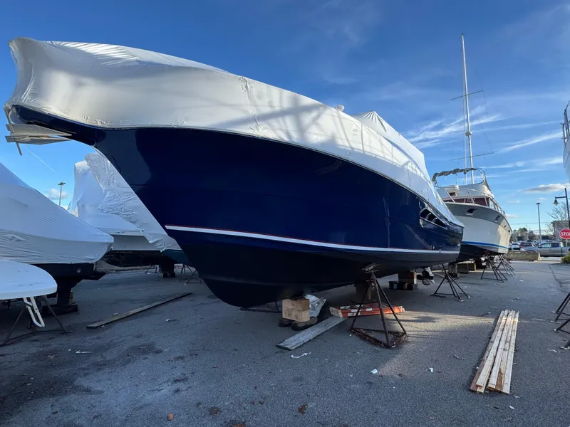 Slide: The Image of 2011 Rampage 34 IPS boat covered and docked on land. - 14